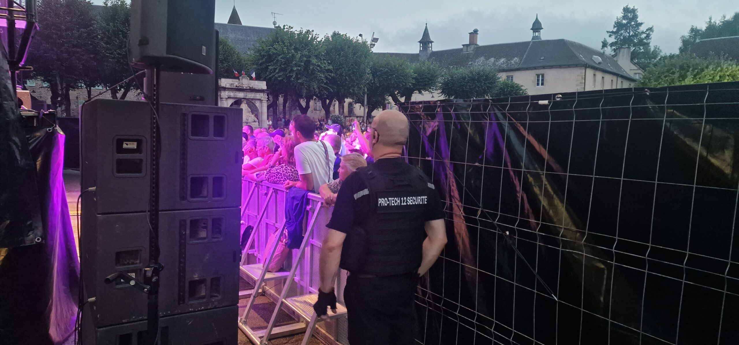Agent Pro Tech 12 surveillant un concert animé à Villefranche-de-Rouergue devant une foule enthousiaste,