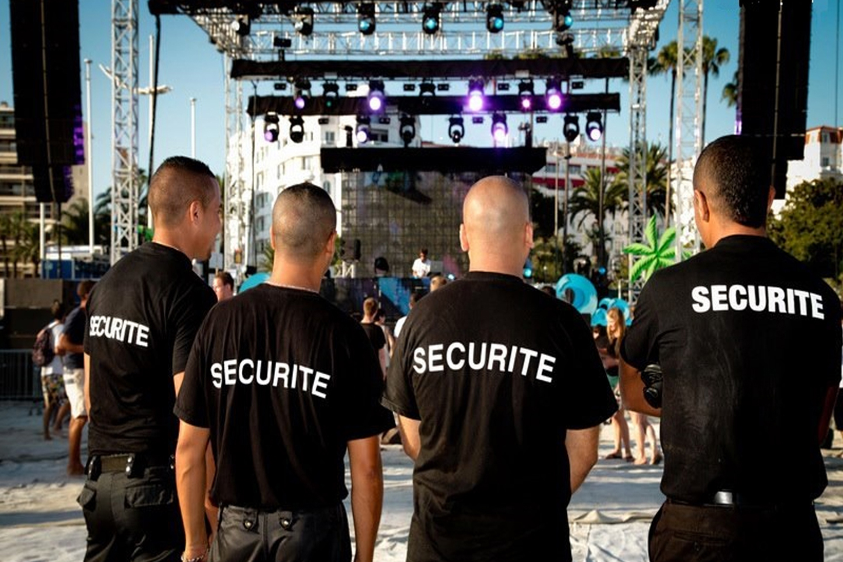 Agents Pro Tech 12 assurent la sécurité d’un événement estival à Villefranche-de-Rouergue devant une scène animée,